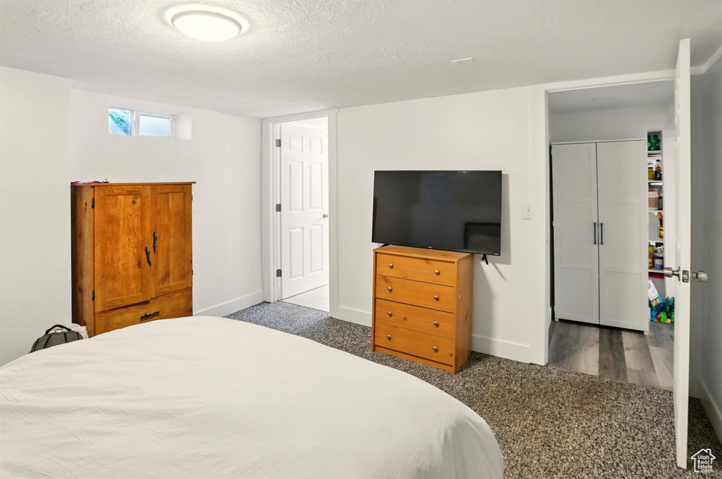 Bedroom featuring a textured ceiling, baseboards, and carpet