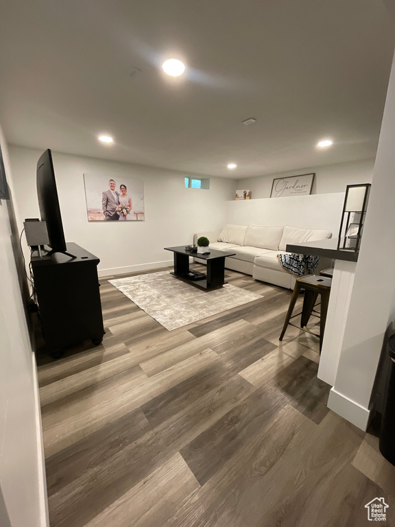 Living room featuring dark wood-style flooring, baseboards, and recessed lighting