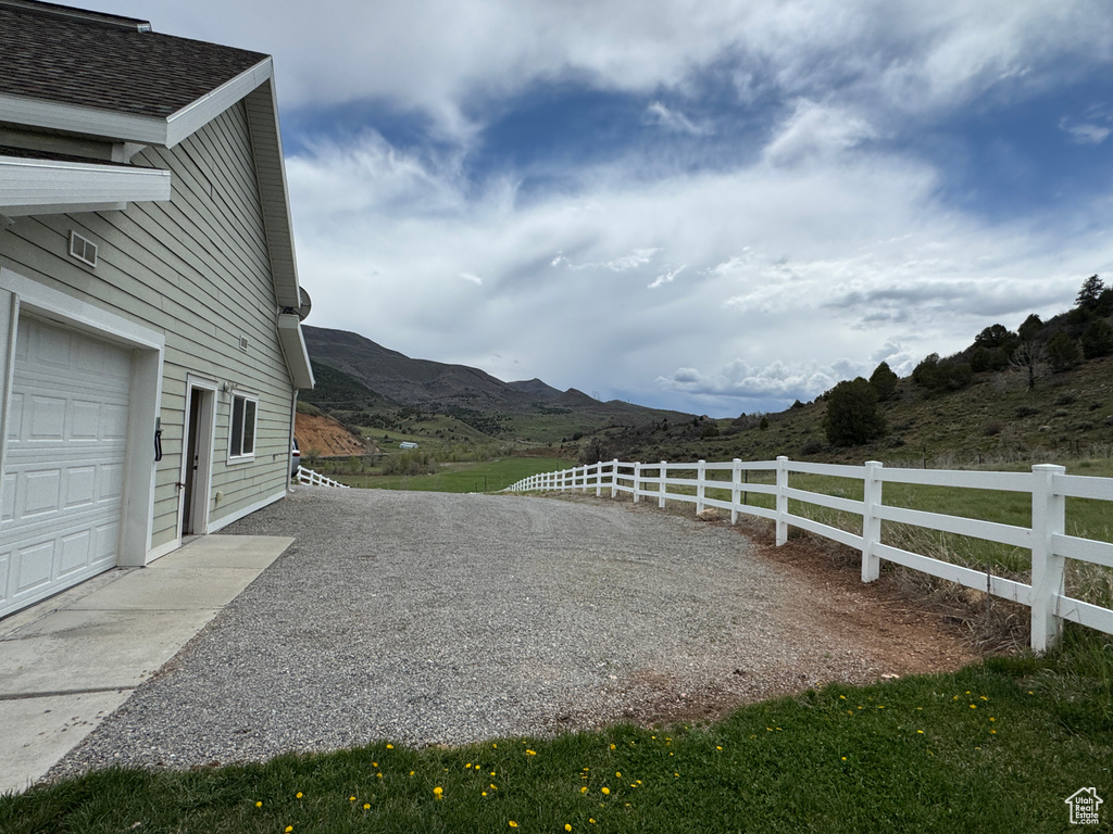 View of yard with fence, a garage, and a mountain view