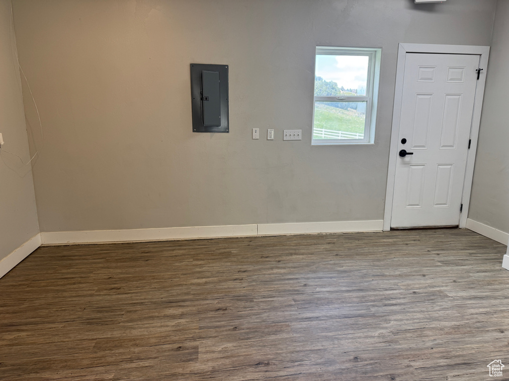 Entrance foyer with electric panel, wood finished floors, and baseboards