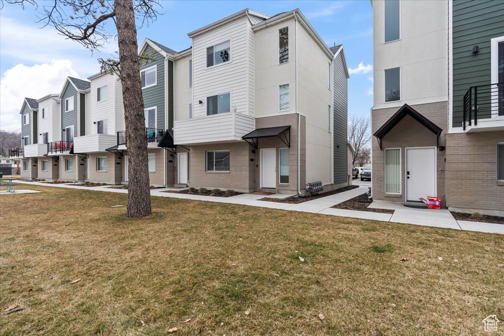 Multi unit property featuring a front lawn and a residential view