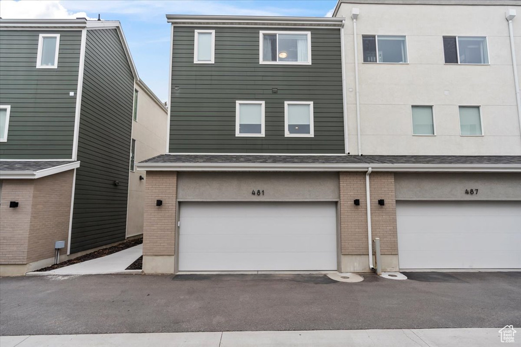 Exterior space with brick siding and an attached garage