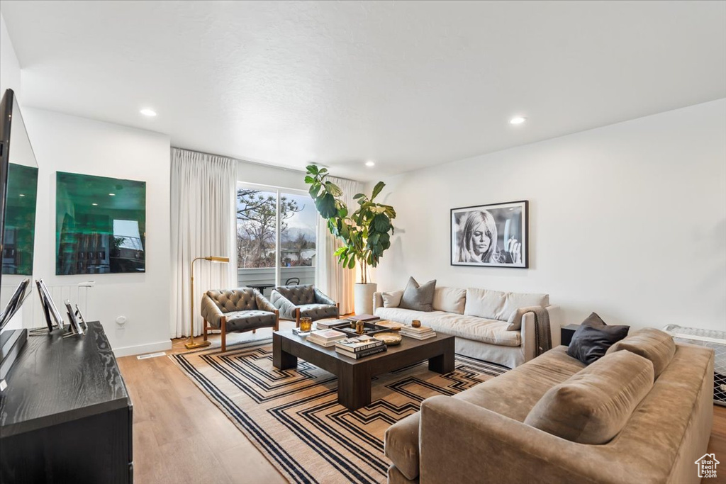 Living room with recessed lighting, light wood finished floors, and baseboards