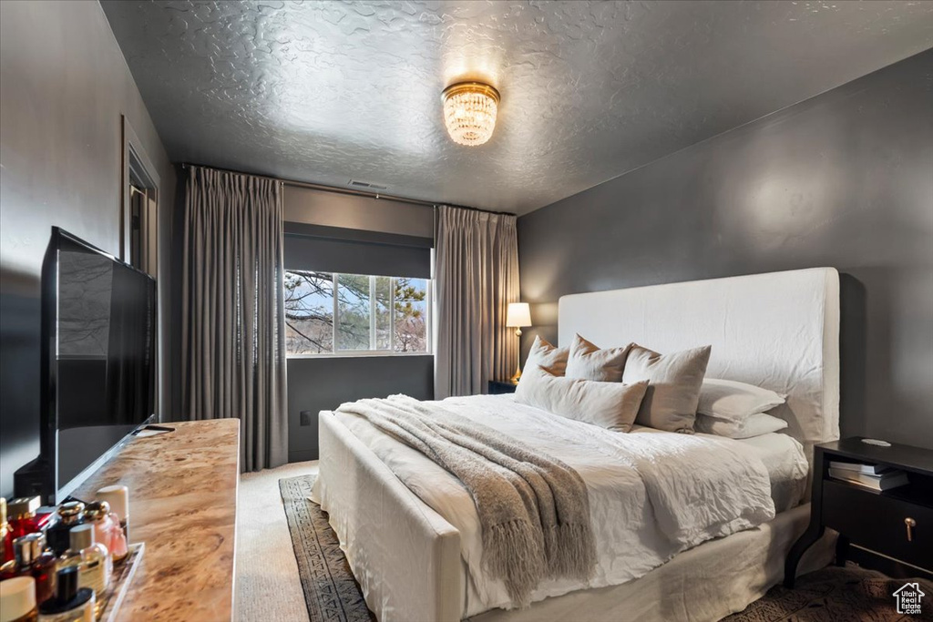 Carpeted bedroom featuring a textured ceiling