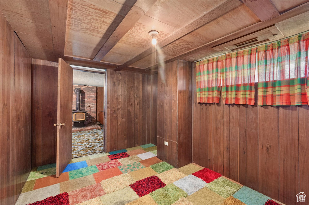 Bedroom with wood ceiling, a wood stove, and wood walls