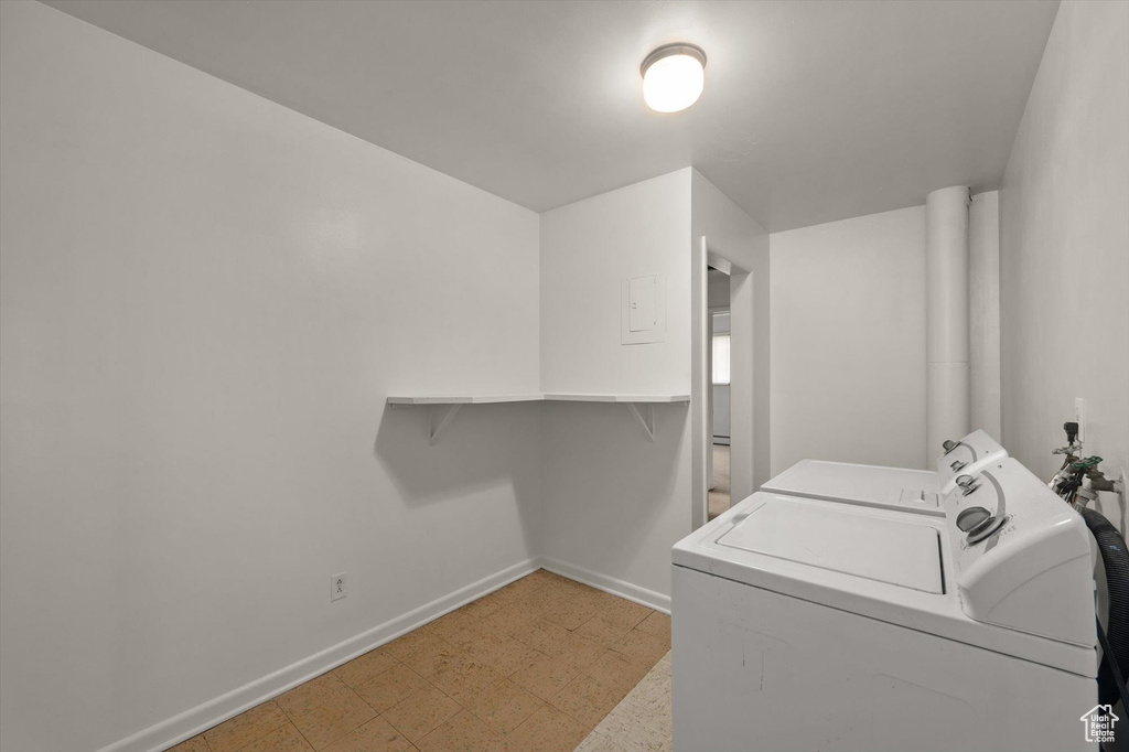 Laundry area with baseboards, laundry area, washer and clothes dryer, and light floors