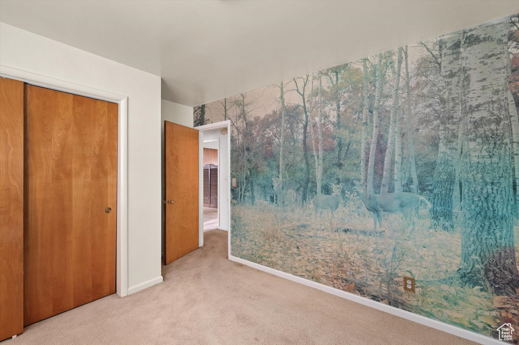 Unfurnished bedroom with baseboards, carpet, and a closet