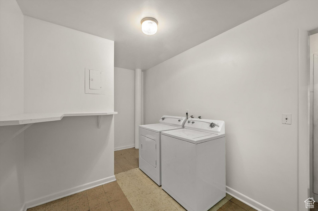 Laundry area featuring washing machine and clothes dryer, laundry area, baseboards, and light floors