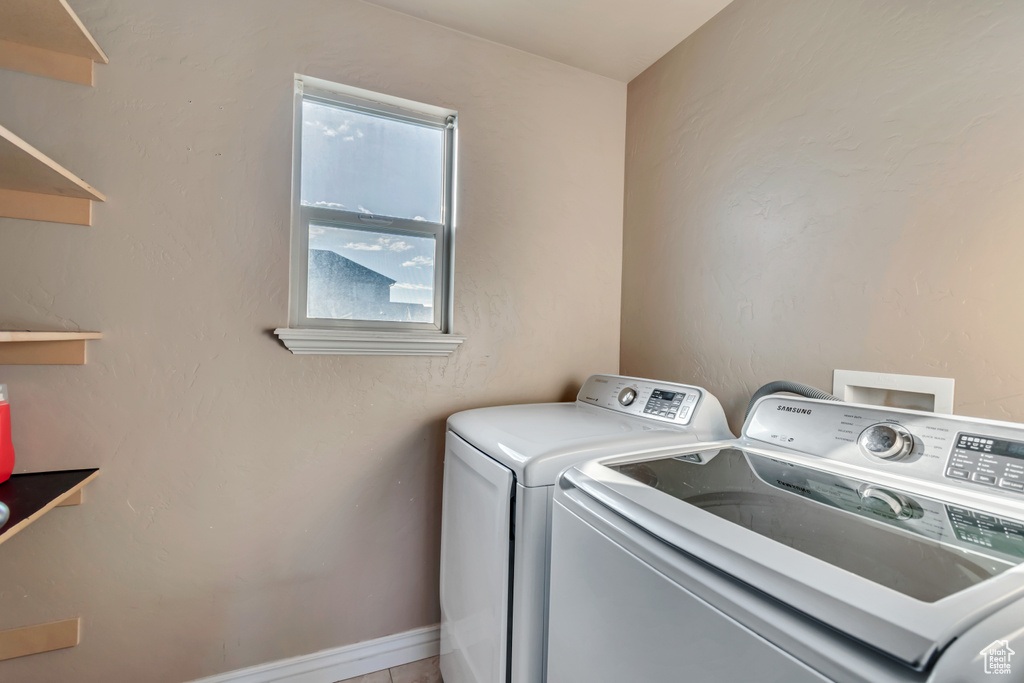 Clothes washing area featuring laundry area and washing machine and dryer