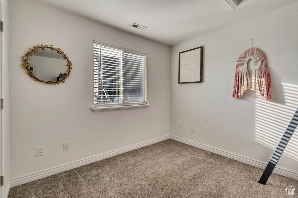 Unfurnished room featuring baseboards, carpet flooring, and visible vents