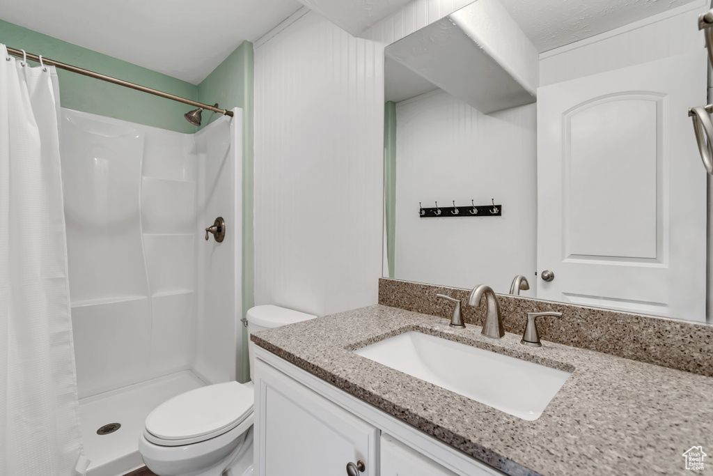 Bathroom featuring vanity, a stall shower, and toilet