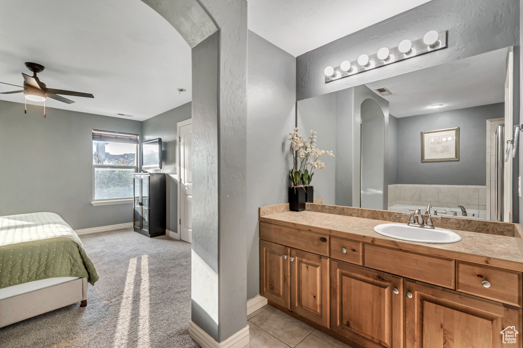 Full bathroom featuring a ceiling fan, baseboards, and vanity