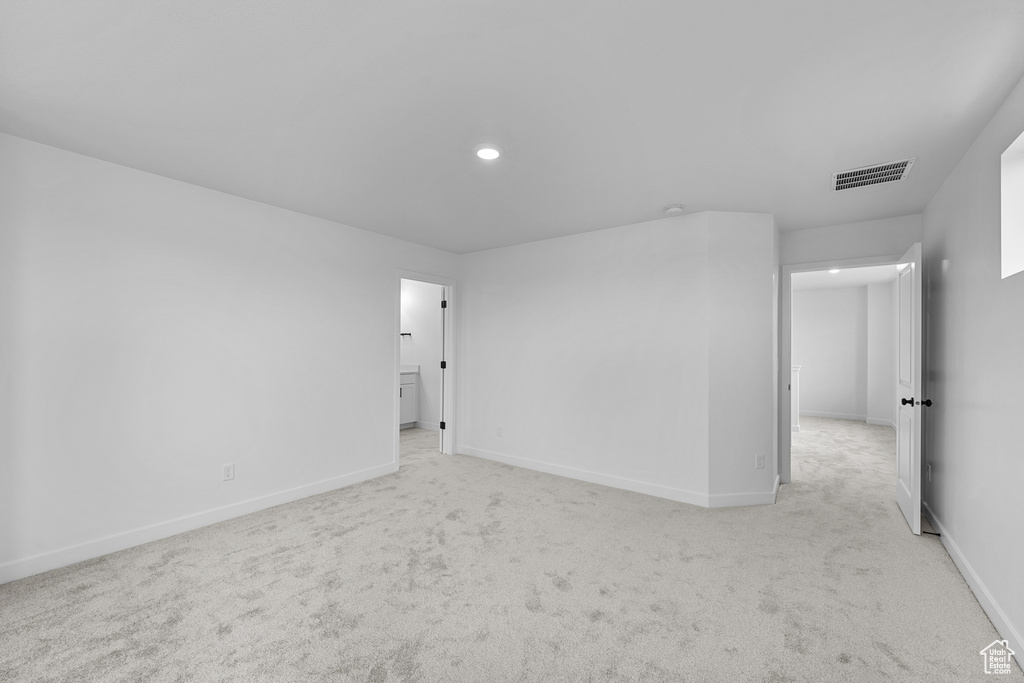 Spare room featuring light colored carpet, baseboards, and visible vents