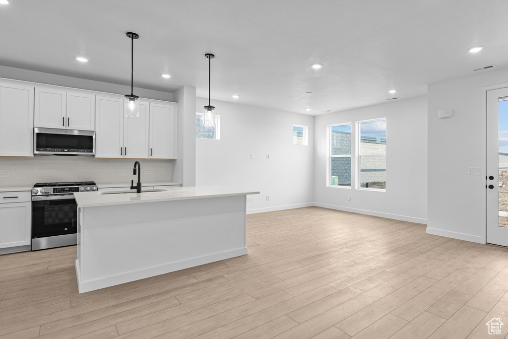 Kitchen featuring recessed lighting, light countertops, and appliances with stainless steel finishes