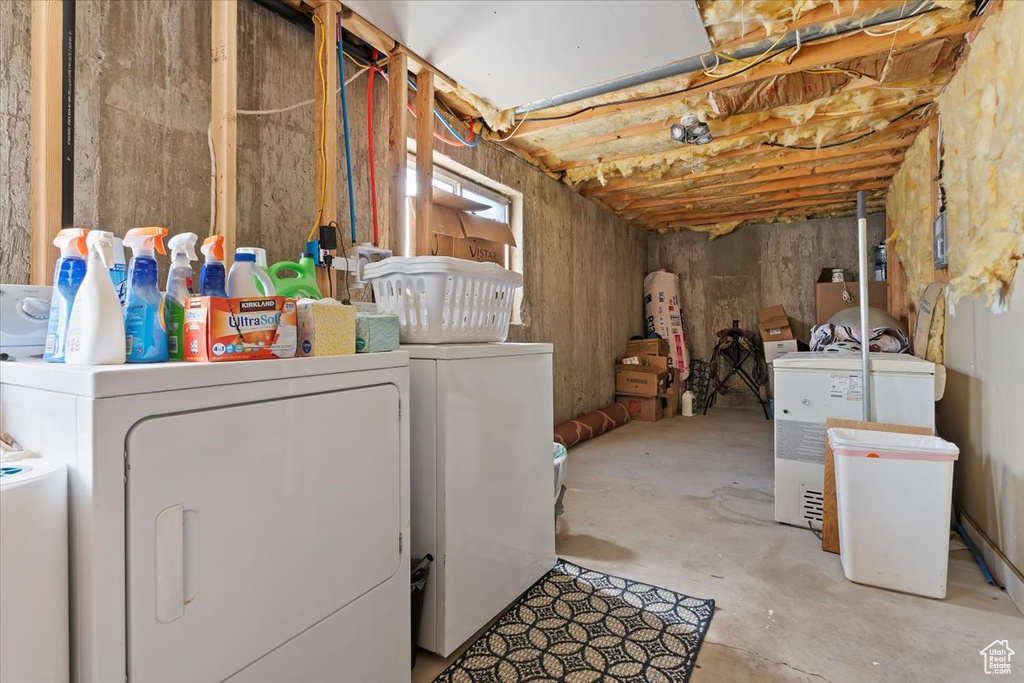 Basement featuring washer and clothes dryer, water heater, and fridge