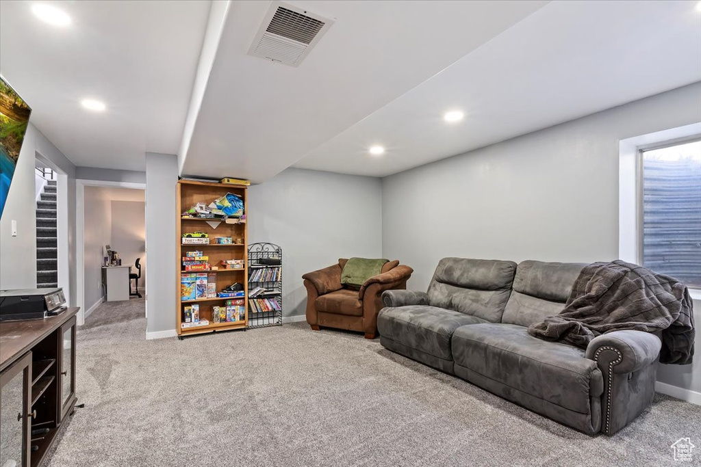 Carpeted living area with baseboards, recessed lighting, and visible vents