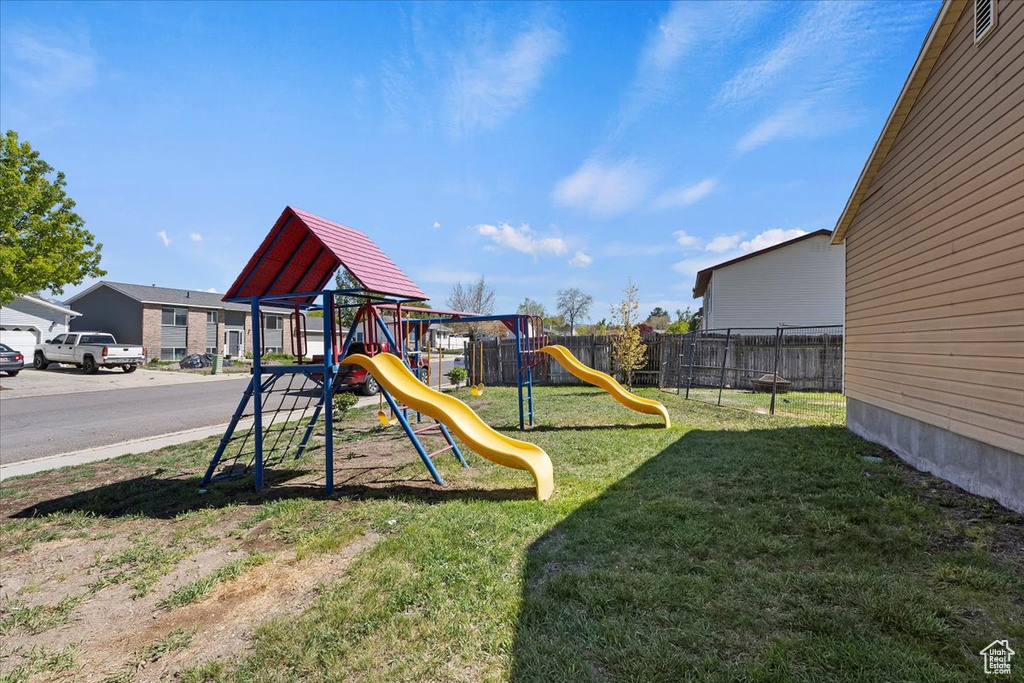 Communal playground featuring fence and a yard