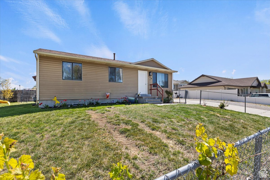 View of front of property with fence and a front yard
