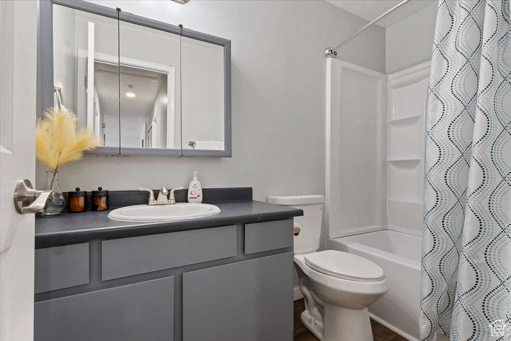 Full bath with vanity, shower / bath combo, and toilet