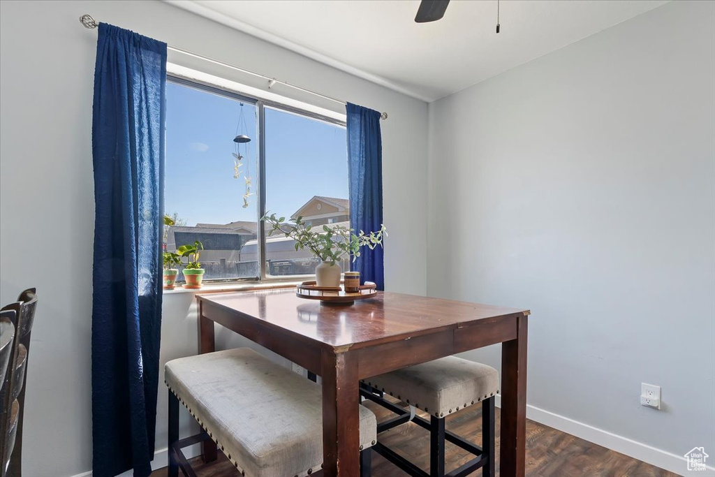 Dining area with baseboards, ceiling fan, and dark wood-type flooring