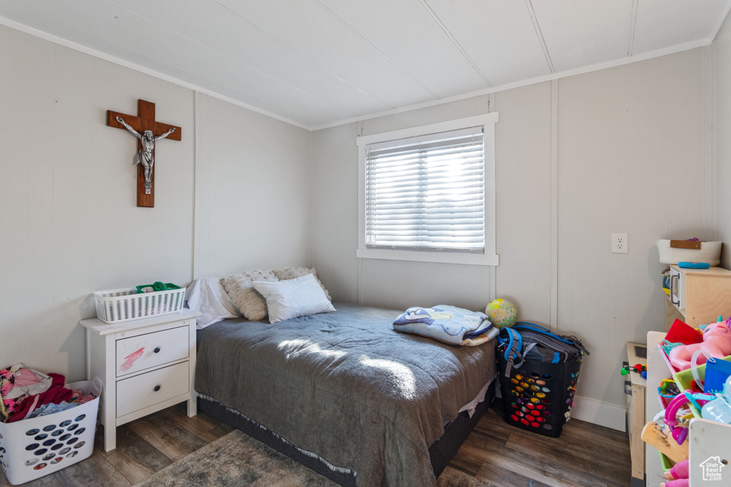 Bedroom featuring crown molding and wood finished floors