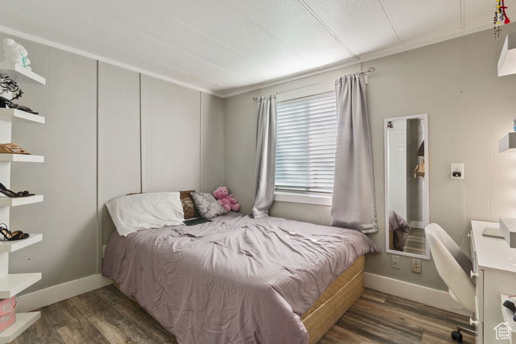 Bedroom with baseboards, ornamental molding, and wood finished floors