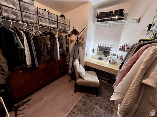 Walk in closet with wood finished floors
