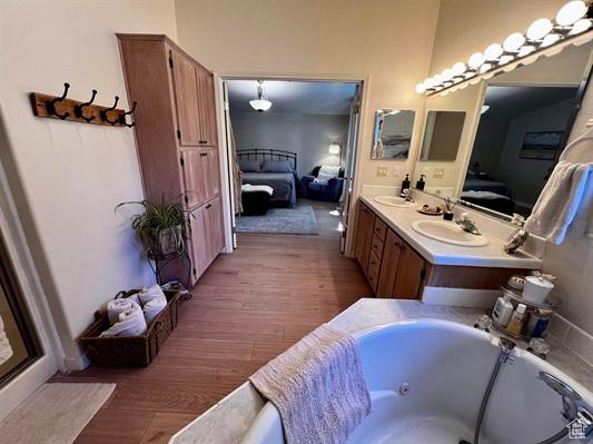 Ensuite bathroom with wood finished floors, a sink, and ensuite bath