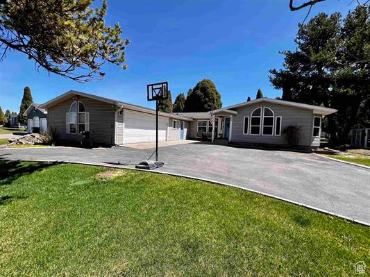 View of front of home featuring a garage, driveway, and a front yard
