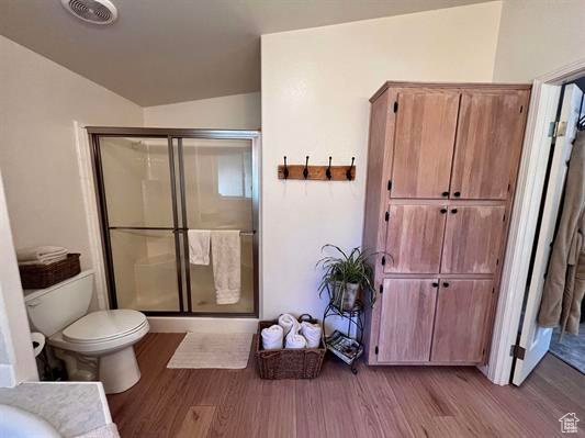 Full bath featuring toilet, visible vents, a shower stall, and wood finished floors