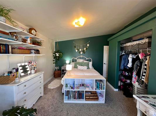 Bedroom featuring an inviting chandelier, carpet flooring, and baseboards