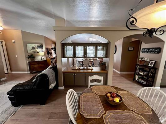 Dining room featuring baseboards, arched walkways, and wood finished floors