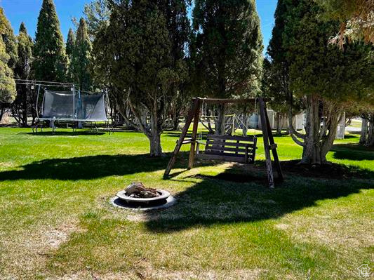 View of yard with a fire pit and a trampoline