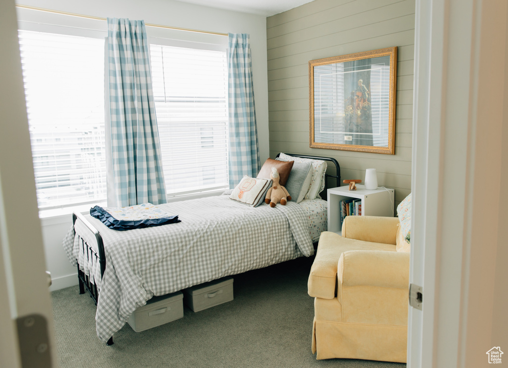 Bedroom with carpet flooring and wooden walls