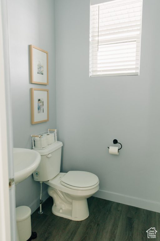 Bathroom with toilet, baseboards, and wood finished floors