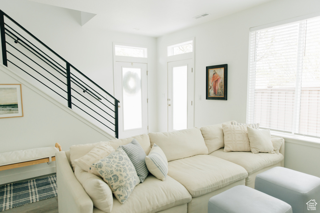Living area featuring stairs, wood finished floors, and visible vents