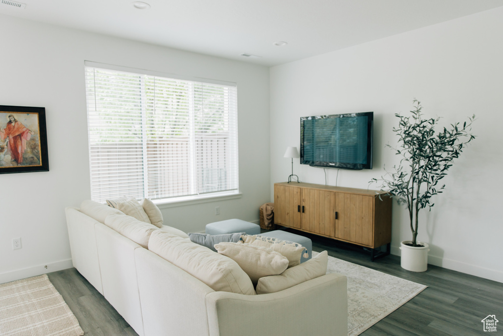 Living room with baseboards, visible vents, and wood finished floors