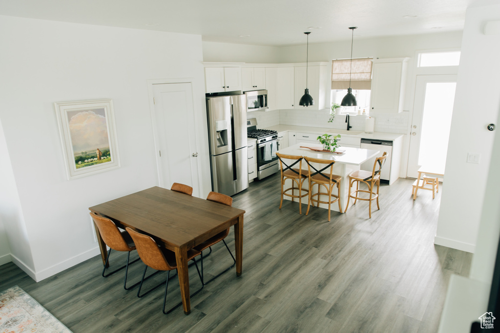 Dining space featuring baseboards and dark wood finished floors