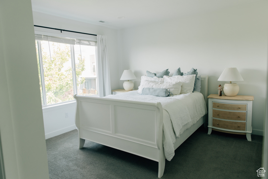 Bedroom with baseboards, visible vents, and dark colored carpet