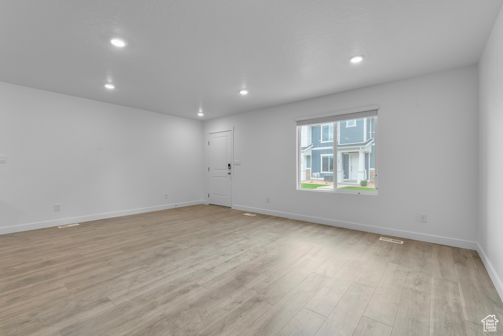 Unfurnished room with recessed lighting, light wood-style flooring, baseboards, and visible vents