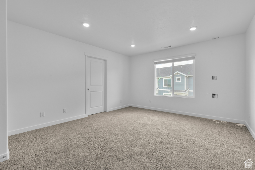 Carpeted empty room featuring baseboards, recessed lighting, and visible vents
