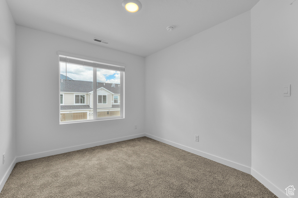 Carpeted spare room with baseboards and visible vents