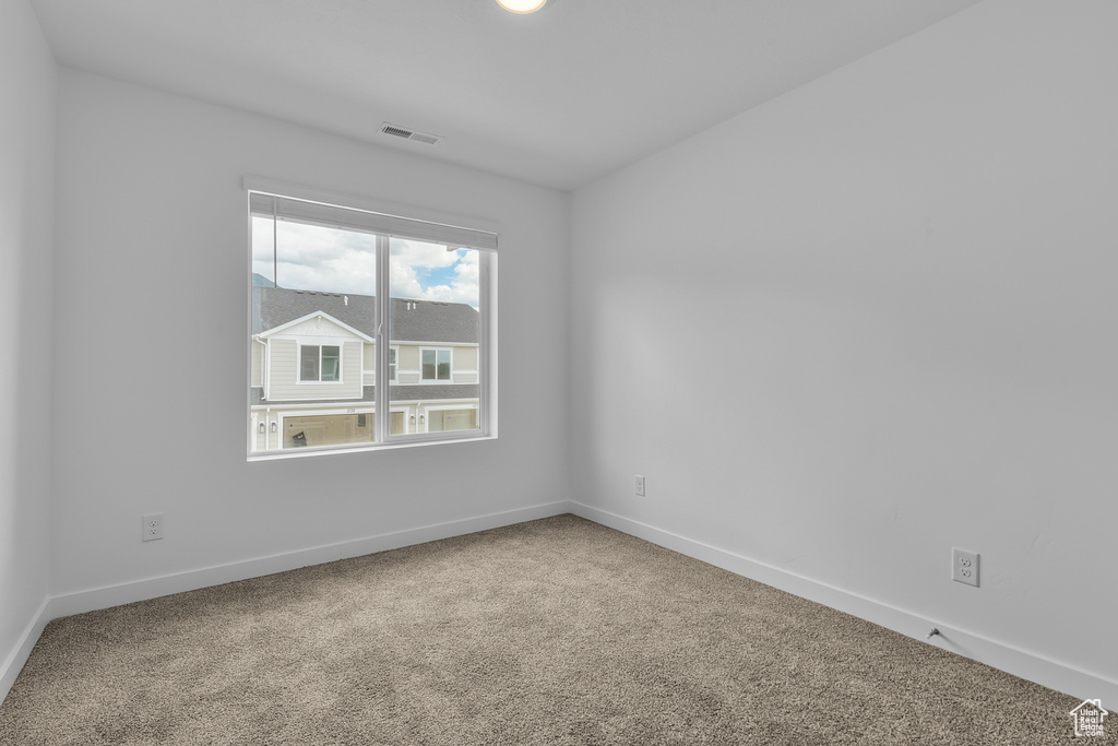 Spare room featuring baseboards, carpet flooring, and visible vents