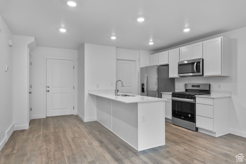 Kitchen featuring visible vents, a sink, appliances with stainless steel finishes, and light wood-type flooring