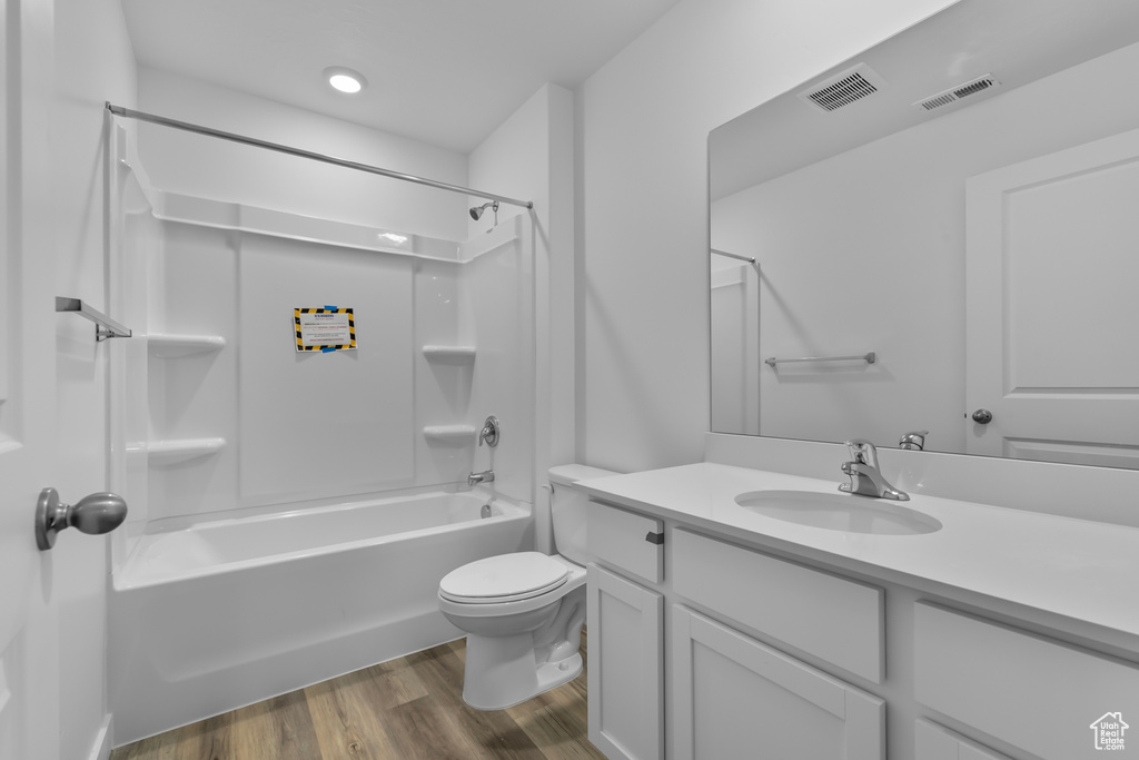 Bathroom featuring toilet, visible vents, wood finished floors, and vanity