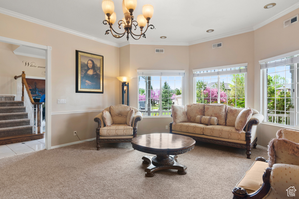 Carpeted living room featuring an inviting chandelier, baseboards, crown molding, and visible vents