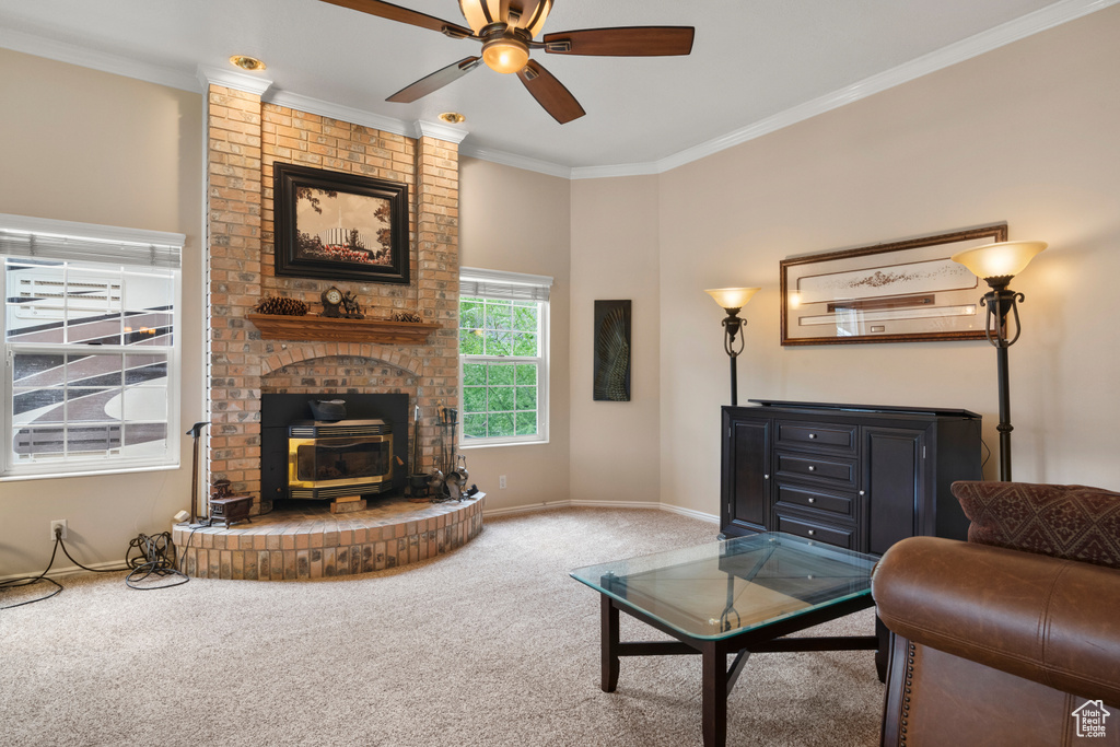 Carpeted living area featuring crown molding, a wood stove, baseboards, and ceiling fan
