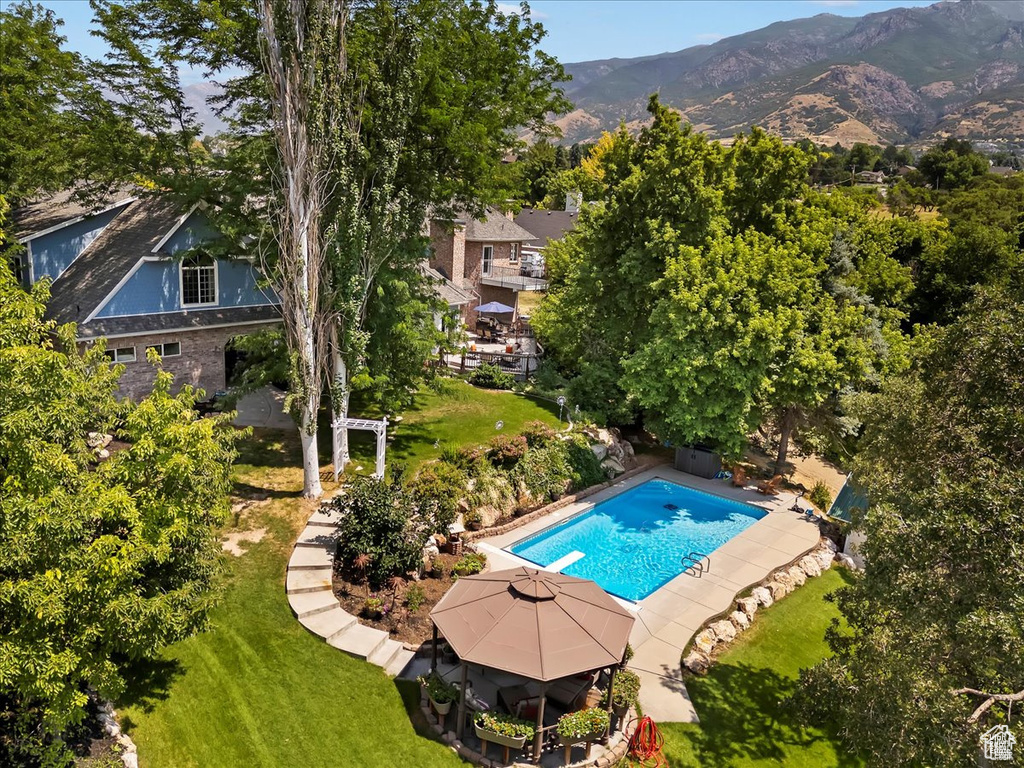 Pool with a yard, a diving board, a mountain view, and a pergola