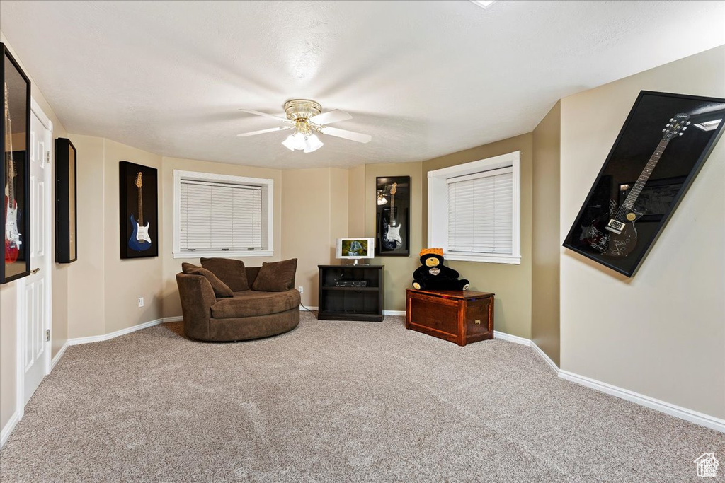 Living area with baseboards, ceiling fan, and carpet