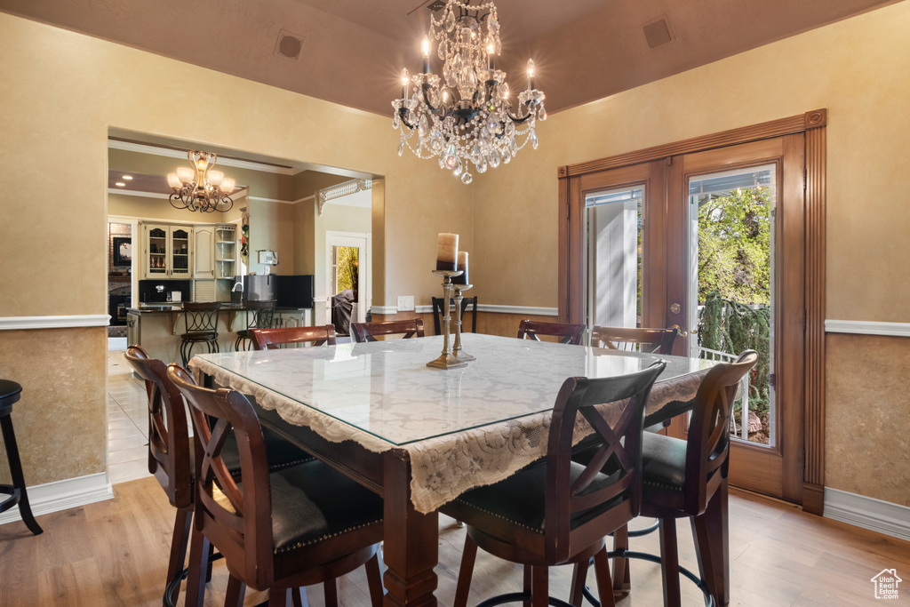 Dining space with an inviting chandelier, visible vents, baseboards, french doors, and light wood finished floors